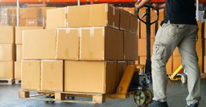 person moving a loaded pallet trolley