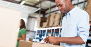 person placing a shipping label on a box